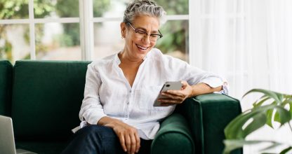 Elderly woman calling her friends and family using a mobile phone at home