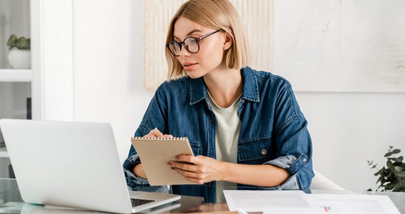 A young woman using her rent ledger to track her rental income.