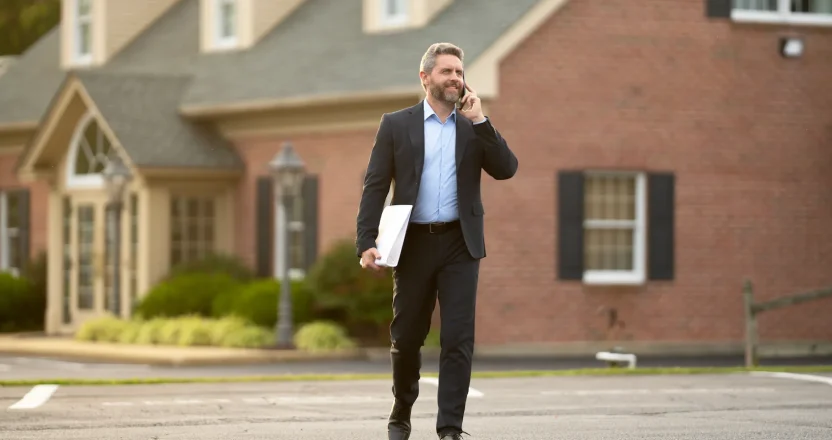 A property manager in kansas out on a stroll talking to his tenant on his phone.